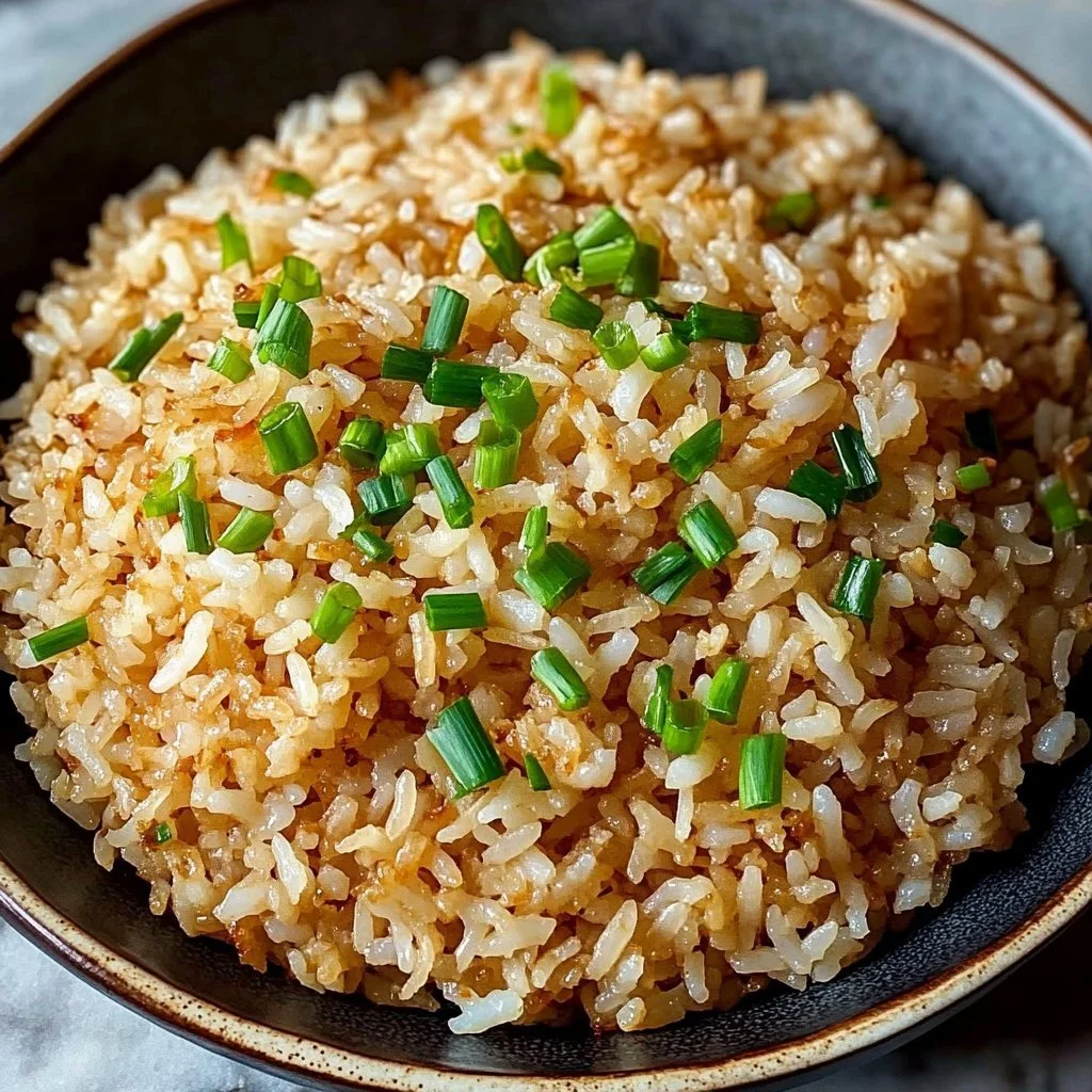 Bowl of crispy coconut rice garnished with herbs and served on a wooden table